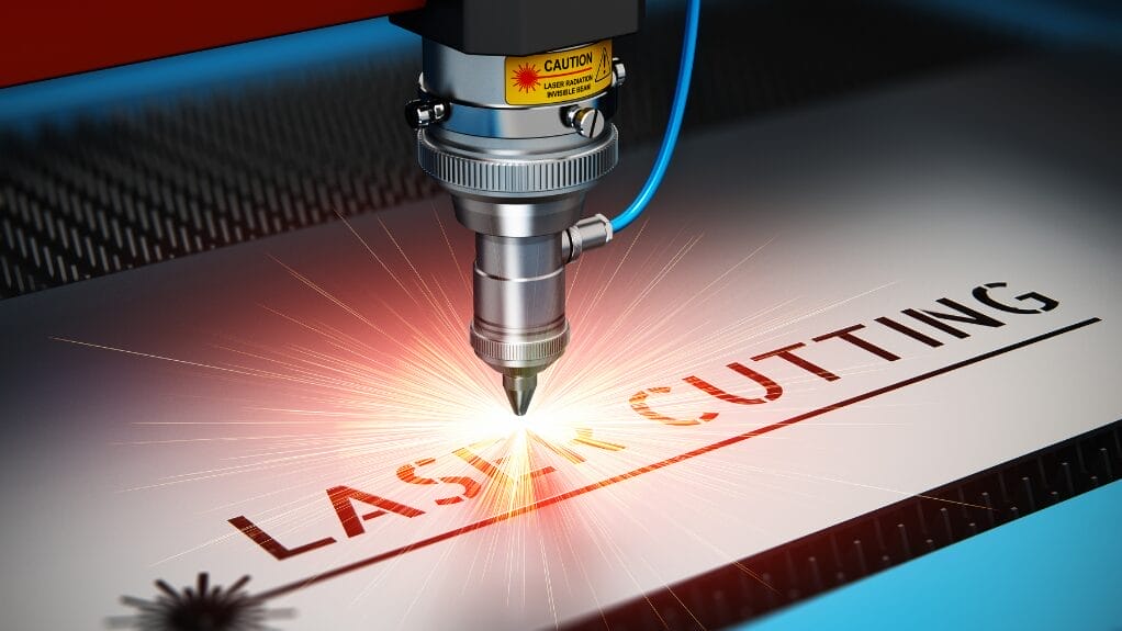 Laser cutting machine engraving "LASER CUTTING" into a metal sheet.