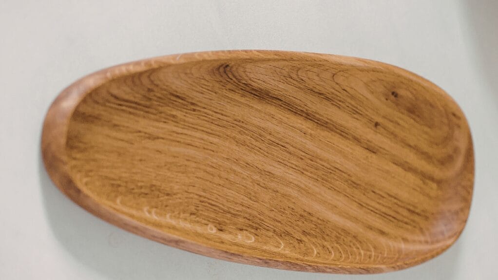Wooden serving tray with visible wood grain, showcasing its natural texture and shape.