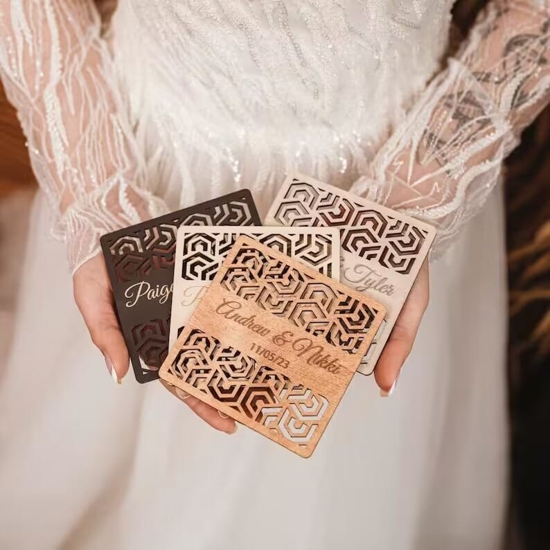 Bride holding personalized wooden coasters wedding favors. Laser-cut geometric design, custom guest gifts.