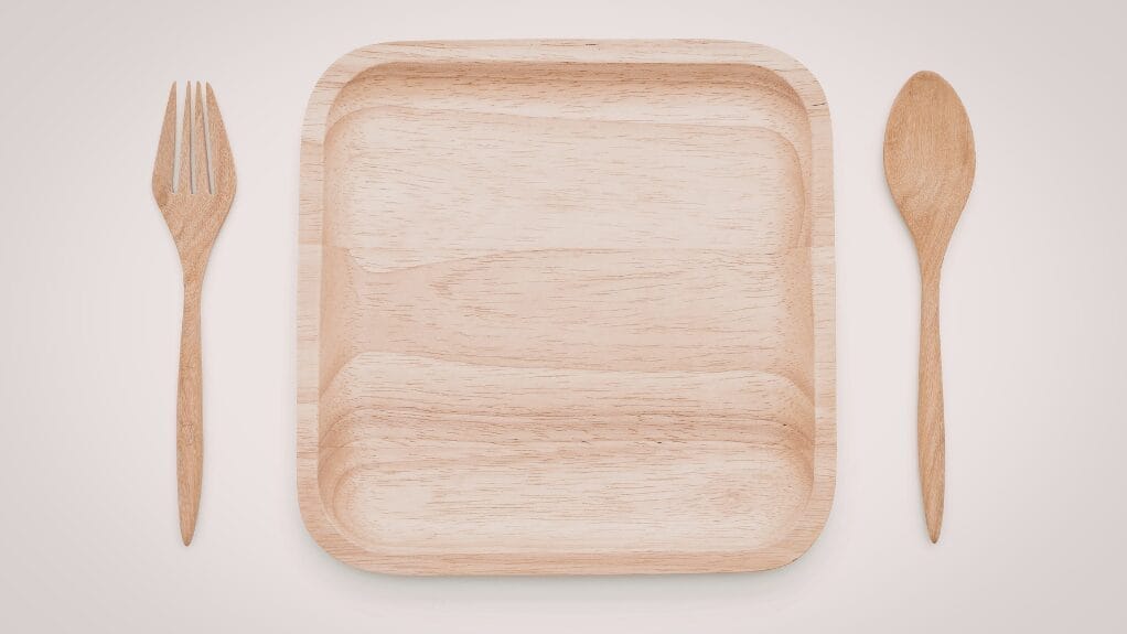 Wooden serving tray with a fork and spoon on either side.