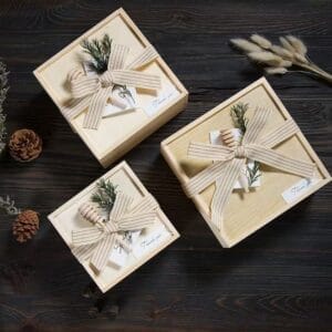 Three wooden gift boxes with striped ribbon, honey dipper, and "Thank you" tag.