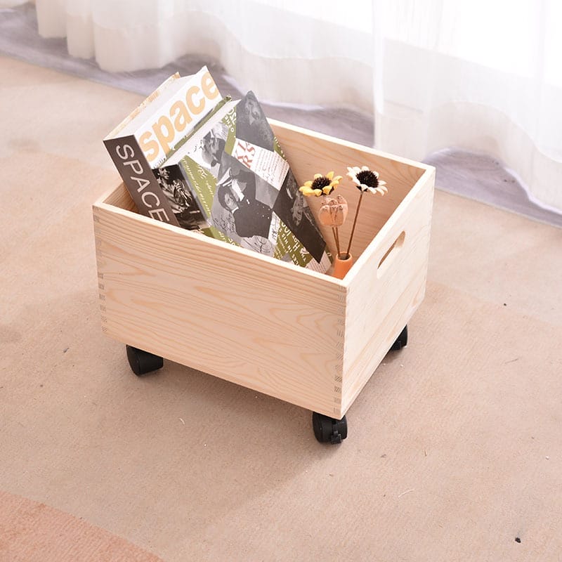 Wooden storage box on wheels with books and flowers.