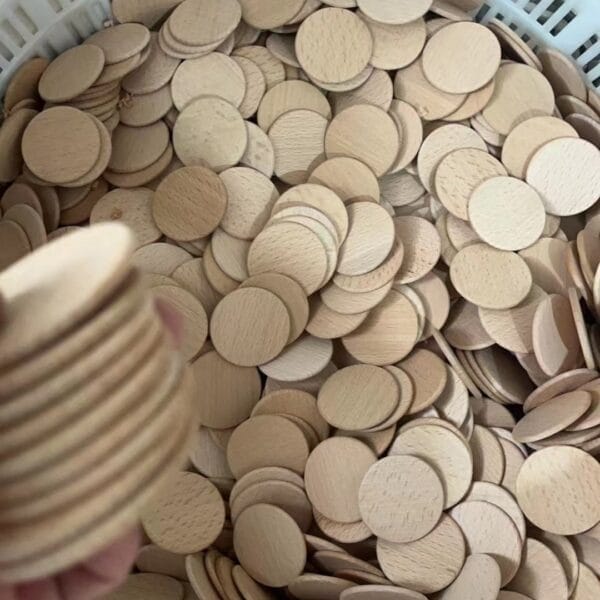 Blank Beech Wooden Nickels: Pile of small, round wooden coins for custom tokens.