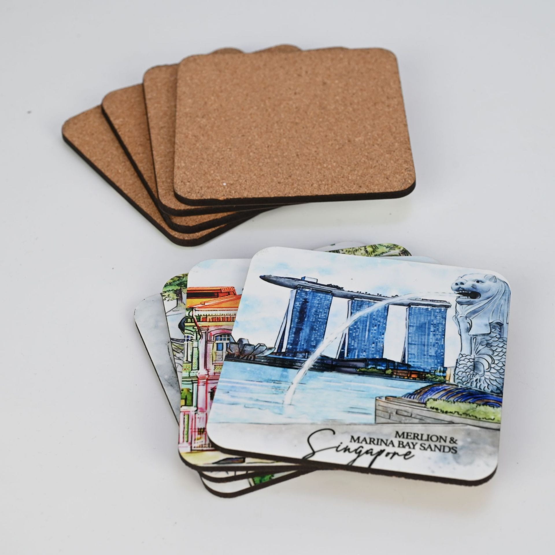 AUTO-DRAFT: Square coasters, cork-backed and featuring Singapore landmarks like the Merlion and Marina Bay Sands