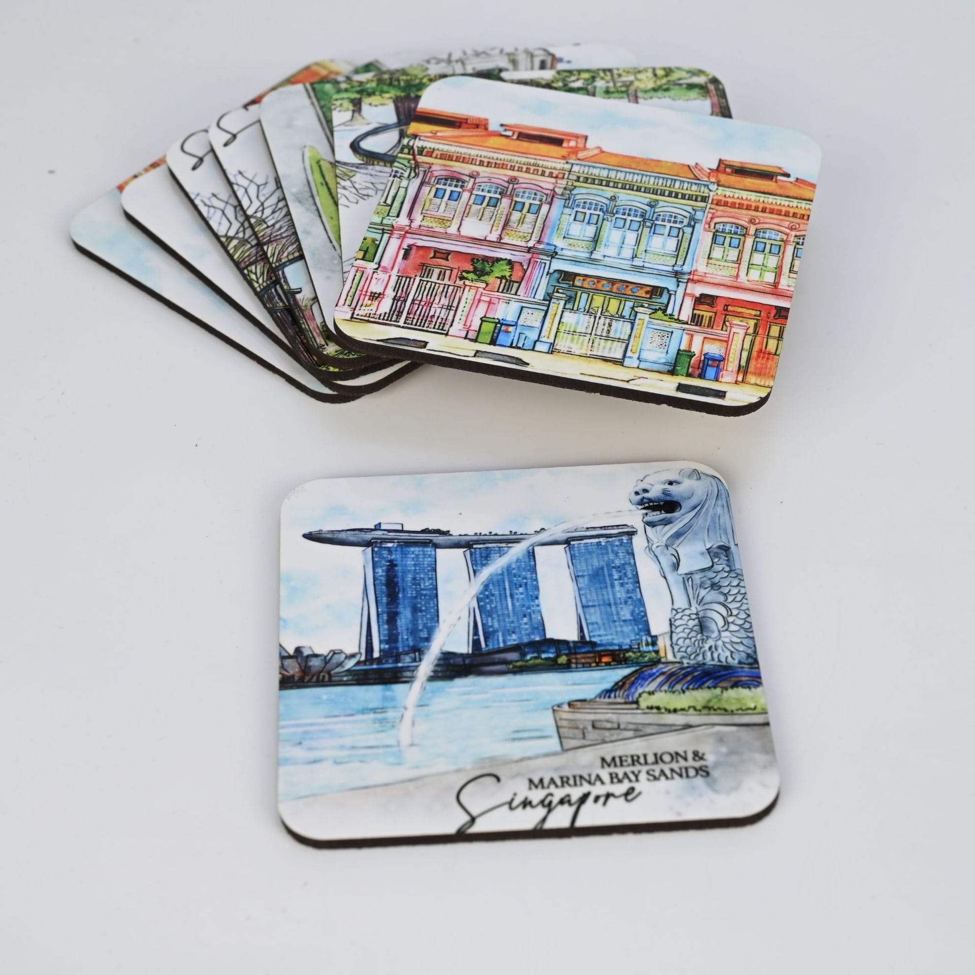 Singapore coasters featuring local landmarks: Colorful buildings & Merlion statue with Marina Bay Sands.