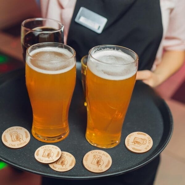 Custom Wooden Drink Tokens: Boxwood party tokens on a tray with beer glasses
