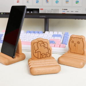 Wooden Animal Phone Wood Holder: Three stands featuring bear, duck, and plain designs, perfect for desk decoration.