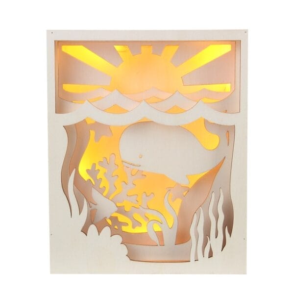 Laser Cut Wood Shadow Box: Wooden light box featuring a whale, sun, and coral reef design, illuminated with warm light.