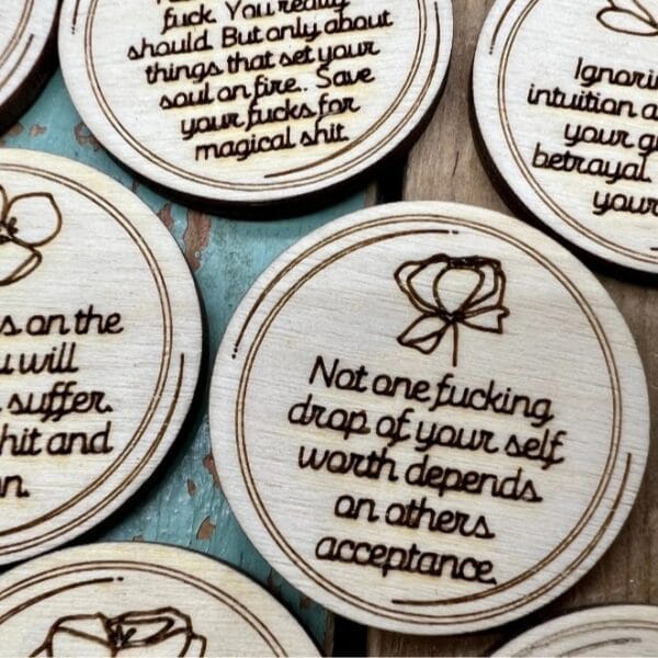 Wooden disc with the quote "Not one fucking drop of your self worth depends on others acceptance