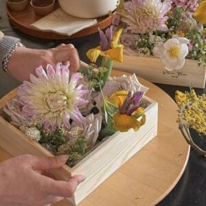 AUTO-DRAFT: Floral arrangement featuring dahlias, roses, and irises in a light wooden box