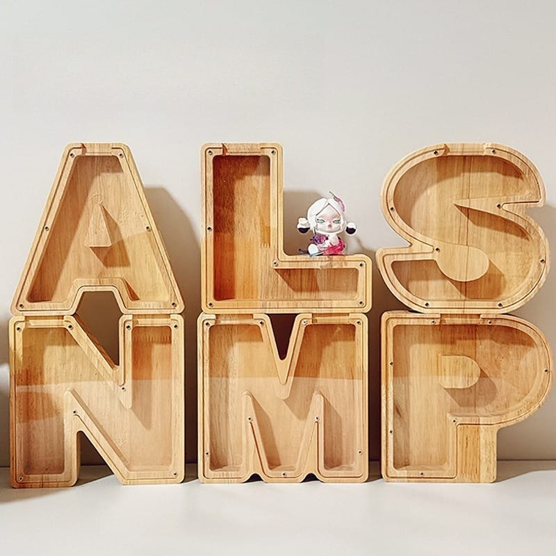 Wooden coin banks shaped as letters A, L, N, M, S, P. Unique personalized piggy banks.