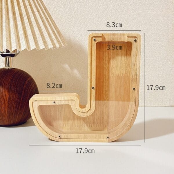 Wooden letter J shaped coin bank with clear acrylic front.