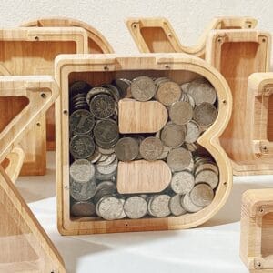 Personalised wooden letter money box: Wooden letter B piggy bank filled with coins.