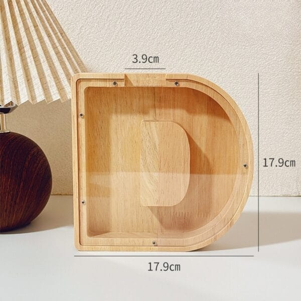 AUTO-DRAFT: Wooden letter D shaped coin bank, 17.9cm height and width, 3.9cm slot.