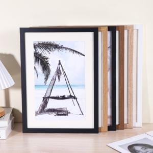 Framed beach scene with a hammock hanging between palm trees, surrounded by picture frames.
