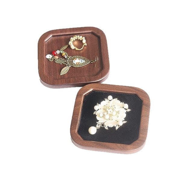 Two square wooden jewelry boxes: one displays a flower brooch, the other earrings