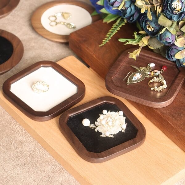 Assorted jewelry trays featuring rings and earrings on wood and velvet display pads.
