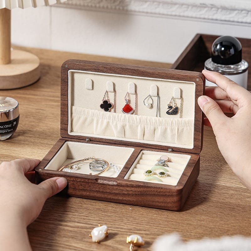 Open wooden jewelry box showcasing necklaces, earrings, and bracelets, offering stylish storage.