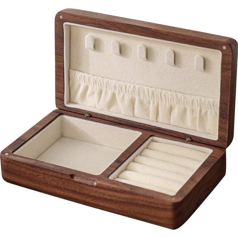 AUTO-DRAFT: Open wooden jewelry box with ring slots, necklace hooks, and compartments for jewelry storage.