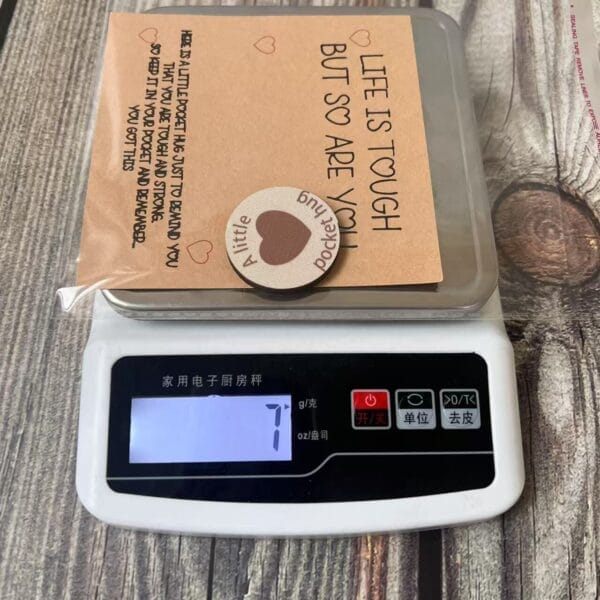 Pocket Hug: Engraved mini coin with encouraging message on a scale, a thoughtful gift for retail and events.