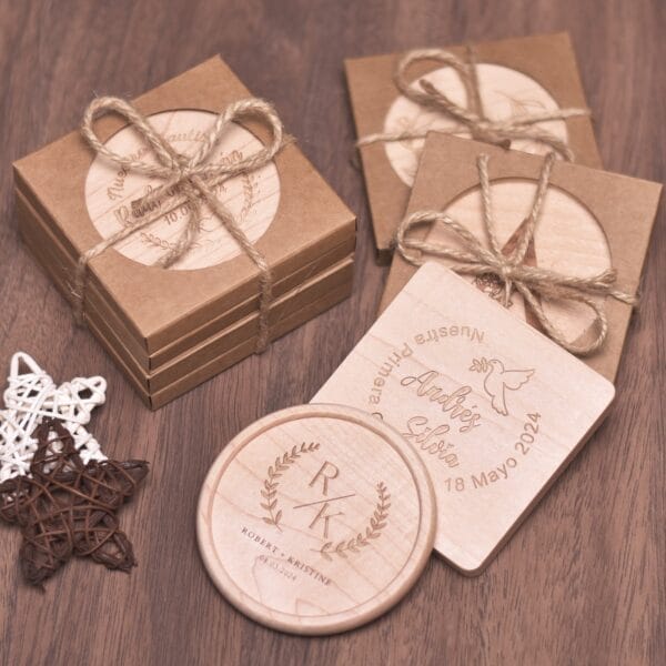 Personalized wooden coasters in gift boxes with twine bows. Engraved designs for weddings and baptisms.