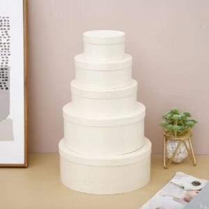 AUTO-DRAFT: Stack of five round, white gift boxes, nesting sizes for presents or storage.