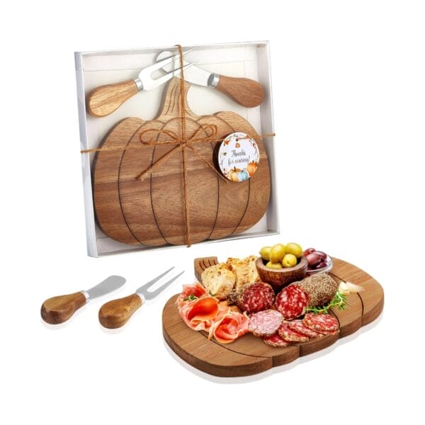 Pumpkin charcuterie board set with cheese knives, olives, bread, salami, and prosciutto.