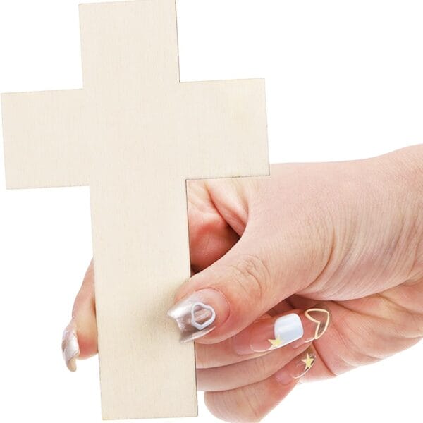 Hand holding a plain wooden Christian cross. Simple faith symbol.