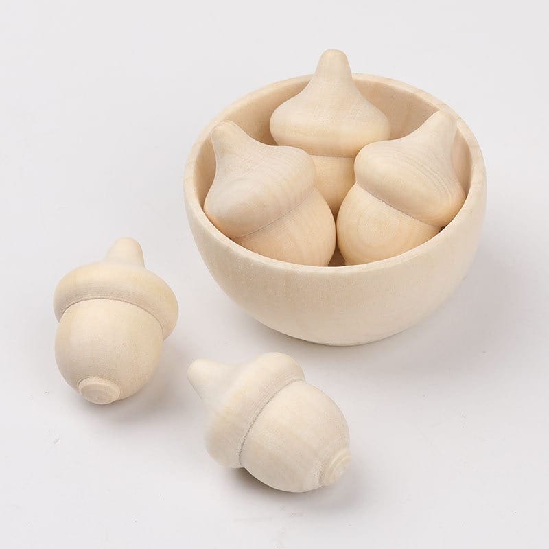 Unfinished Wooden Bowls Wholesale: Wooden acorns in a small bowl, two acorns scattered outside, natural wood finish