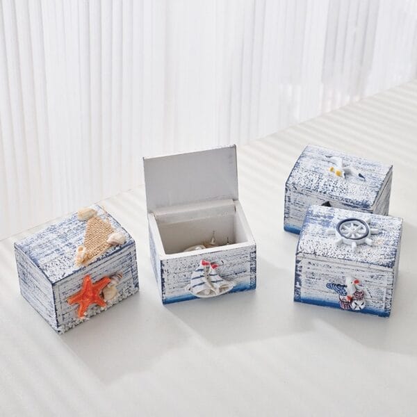 Nautical decorative boxes. Set of four small, square wooden boxes with sea-themed embellishments.