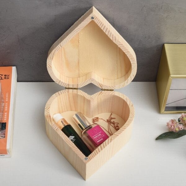 wooden heart boxes wholesale: wooden heart-shaped box holding perfume, a tube, and gold jewelry