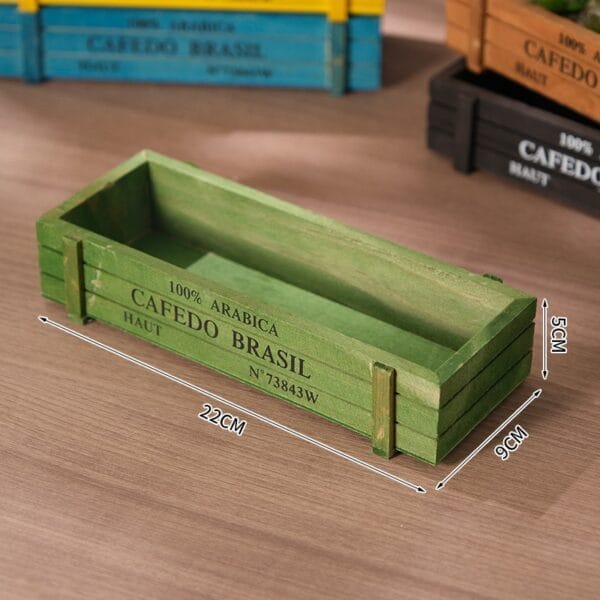 Green wooden crate with "100% Arabica Cafedo Brasil" printed on the side.