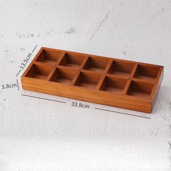 Wooden tray with ten compartments, dimensions 33.8cm x 13.5cm x 3.8cm.